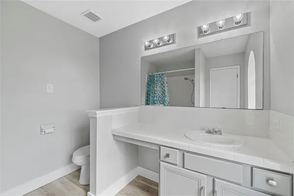 a bathroom with a sink a toilet and a mirror