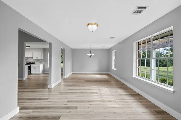 a view of a hallway with wooden floor and a living room