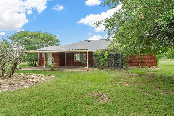a backyard of a house with table and chairs