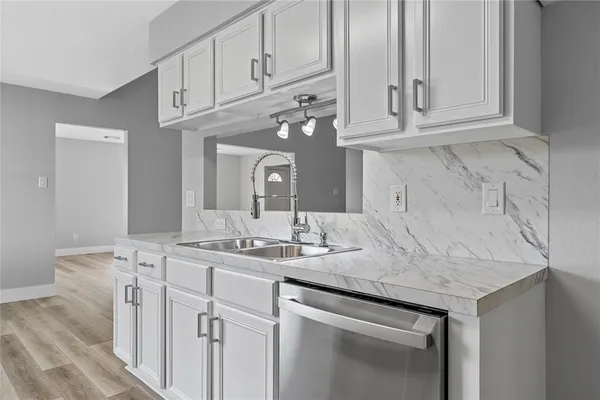 a kitchen with stainless steel appliances granite countertop a sink and cabinets