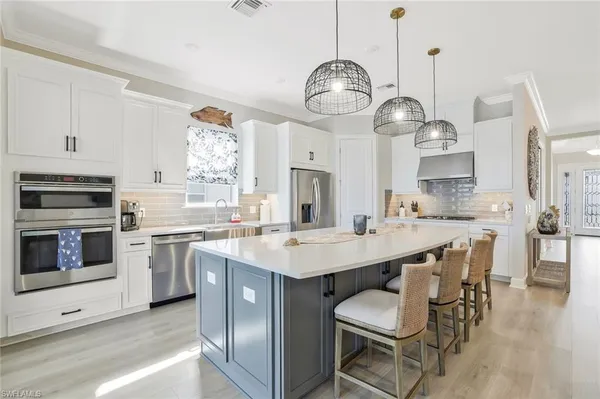 a kitchen with stainless steel appliances a sink a stove and a wooden floors