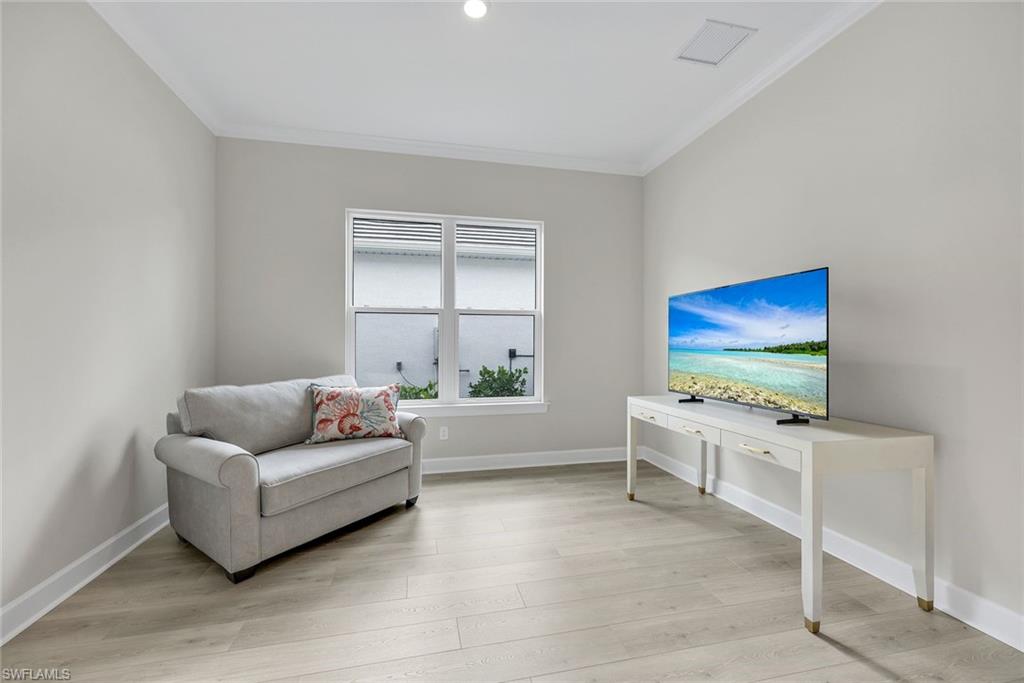 15804 Derna Street Naples, FL 34114 - Photo 15 of 28 Living area featuring light wood-style floors and crown molding