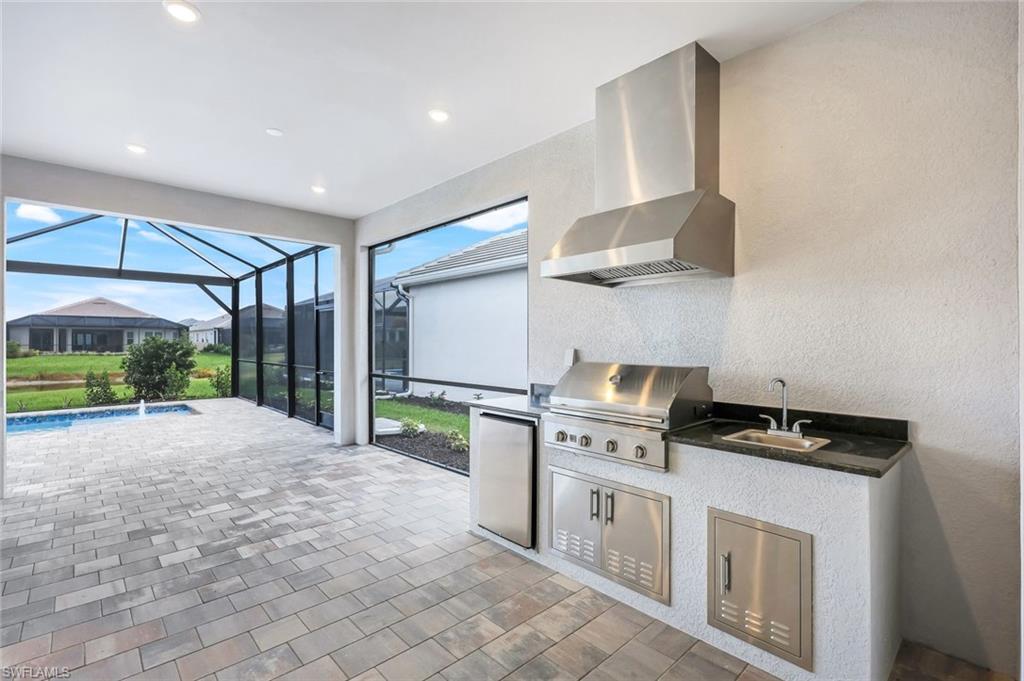 15804 Derna Street Naples, FL 34114 - Photo 16 of 22 View of patio / terrace with an outdoor kitchen, a sunroom, an outdoor pool, and a lanai