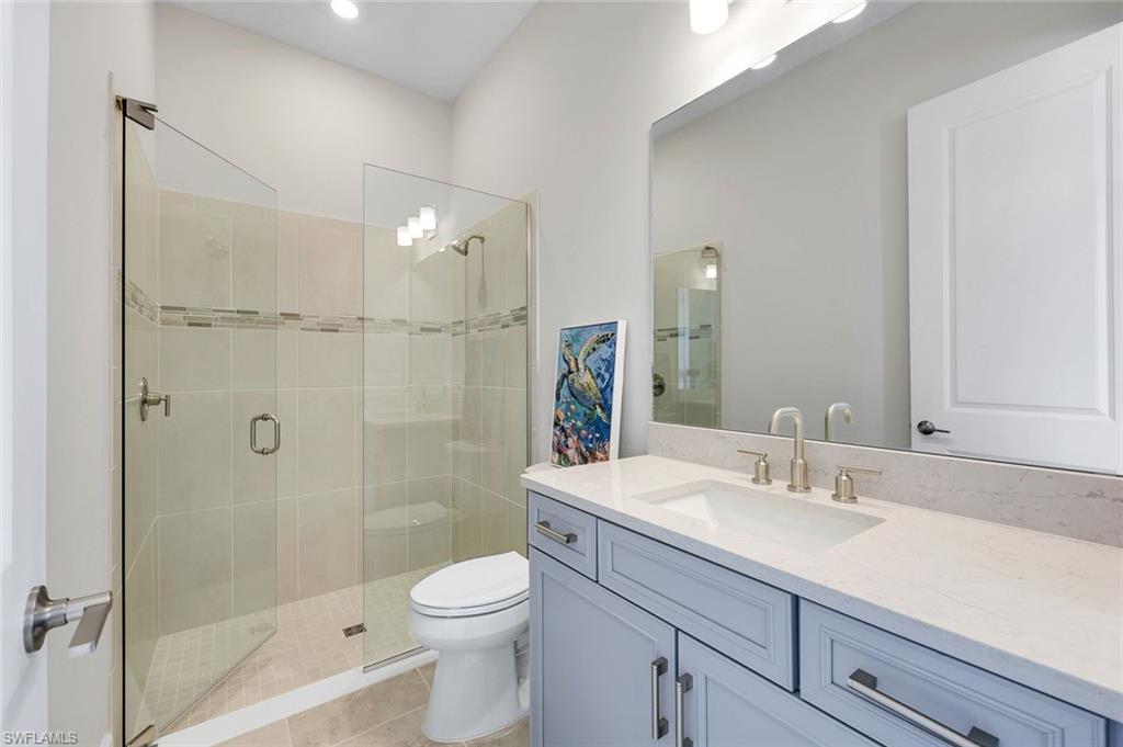 15804 Derna Street Naples, FL 34114 - Photo 17 of 28 Full bathroom with vanity, a stall shower, and light tile patterned floors