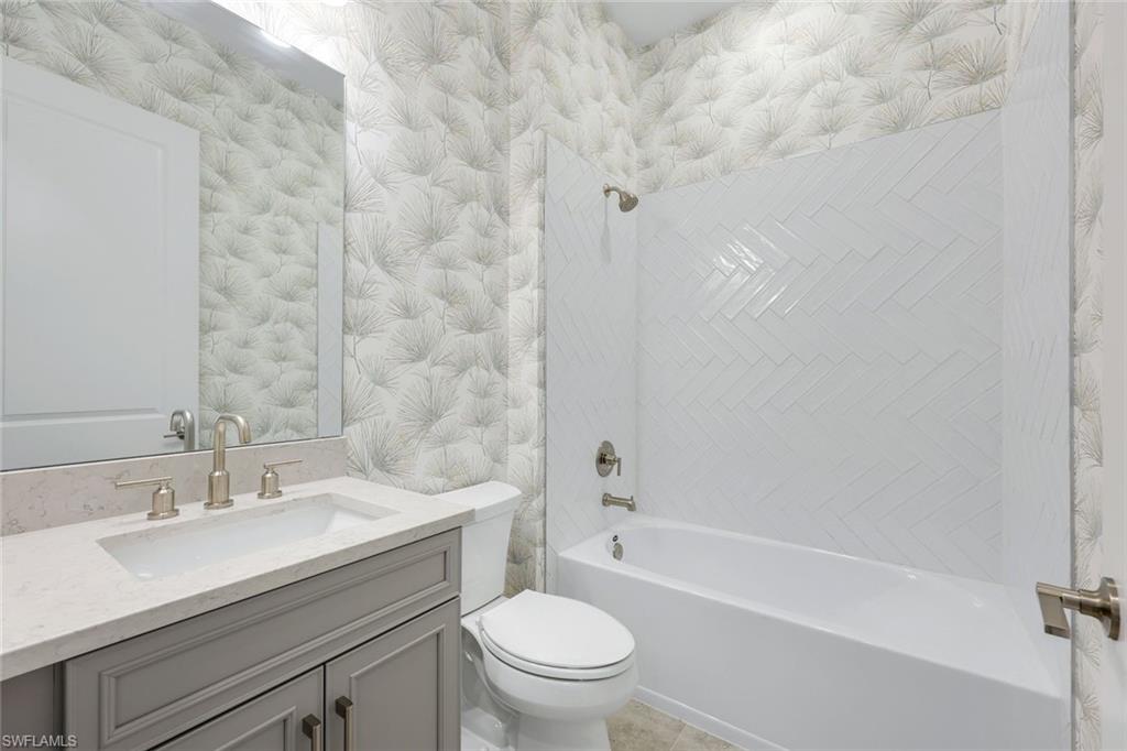 15804 Derna Street Naples, FL 34114 - Photo 19 of 28 Bathroom with wallpapered walls, vanity, and shower / bathtub combination