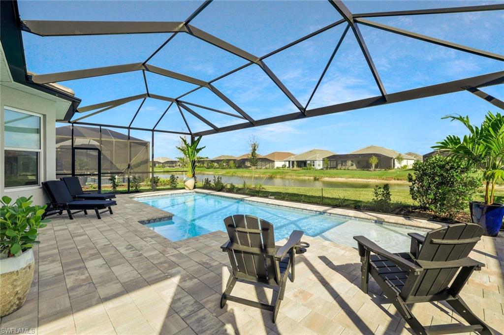 15804 Derna Street Naples, FL 34114 - Photo 2 of 28 Outdoor pool featuring a water view, a sunroom, a patio, a residential view, and a lanai