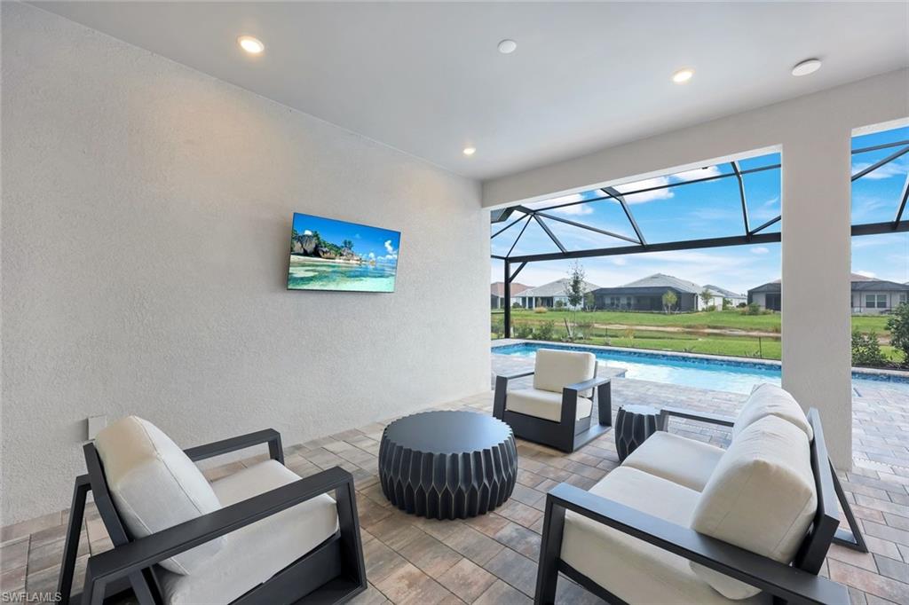 15804 Derna Street Naples, FL 34114 - Photo 20 of 28 View of patio / terrace with a sunroom, an outdoor pool, a lanai, a residential view, and outdoor lounge area