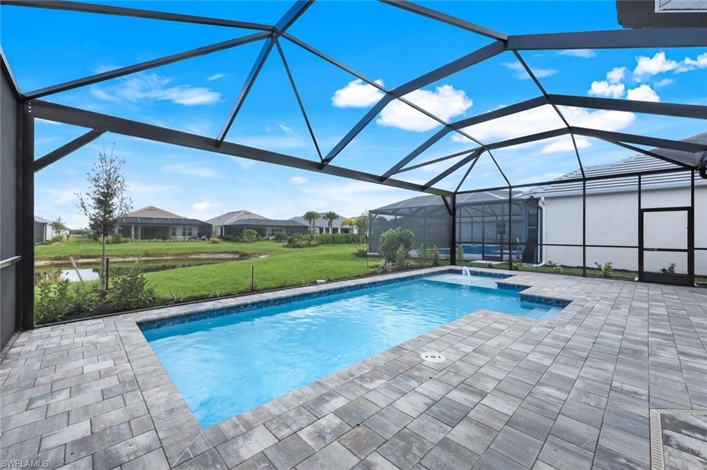 15804 Derna Street Naples, FL 34114 - Photo 21 of 22 Outdoor pool with a sunroom, a lanai, a hot tub, a lawn, and a patio