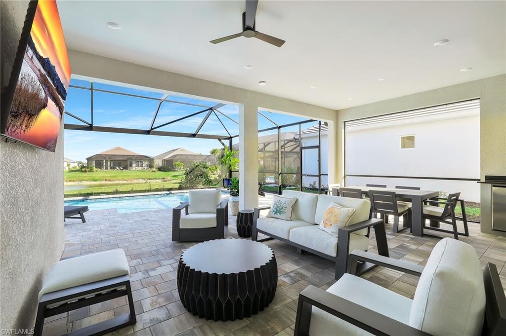 15804 Derna Street Naples, FL 34114 - Photo 22 of 28 View of patio / terrace featuring a sunroom, outdoor lounge area, ceiling fan, an outdoor pool, and a lanai