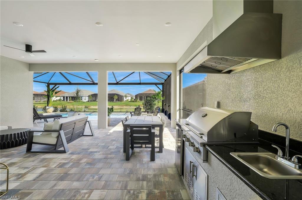 15804 Derna Street Naples, FL 34114 - Photo 23 of 28 View of patio with a sunroom, a residential view, an outdoor pool, and a lanai