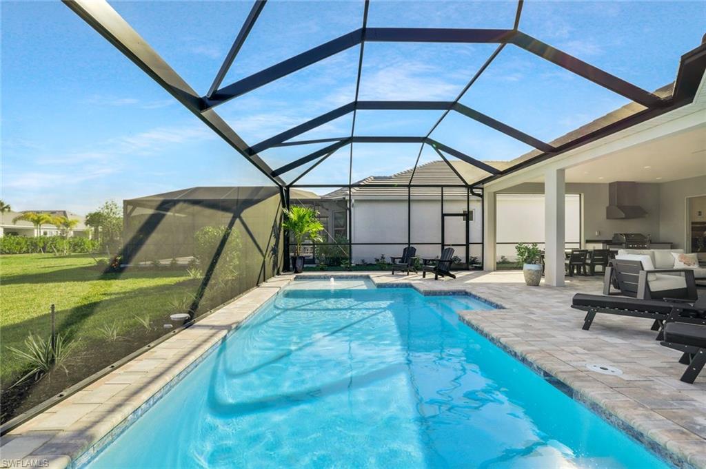 15804 Derna Street Naples, FL 34114 - Photo 24 of 28 Outdoor pool featuring a sunroom, a patio area, glass enclosure, a lawn, and grilling area