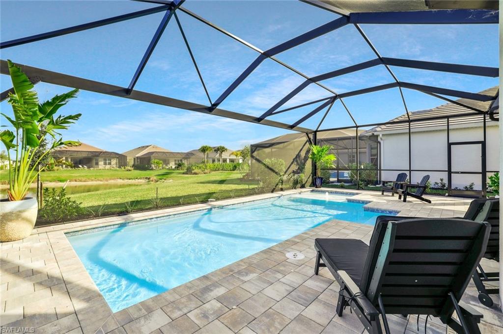 15804 Derna Street Naples, FL 34114 - Photo 26 of 28 Outdoor pool featuring a sunroom, a patio, glass enclosure, a lawn, and a residential view