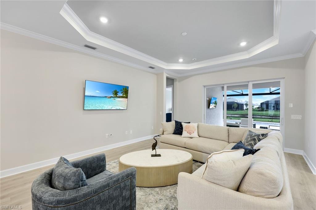 15804 Derna Street Naples, FL 34114 - Photo 3 of 22 Living room with light wood-type flooring, a tray ceiling, crown molding, and recessed lighting