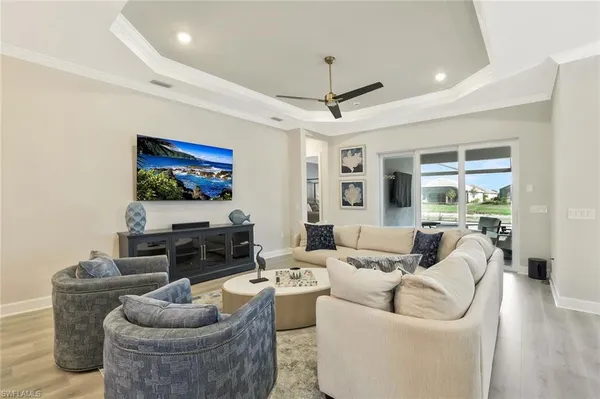 a living room with furniture a flat screen tv and a large window