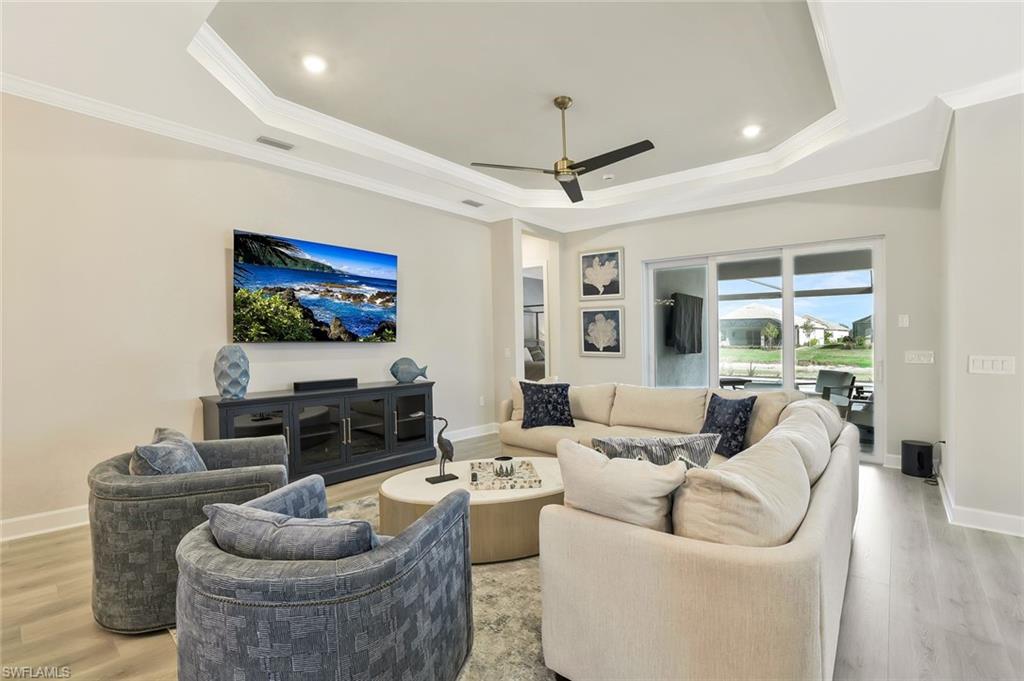 15804 Derna Street Naples, FL 34114 - Photo 5 of 28 Living room featuring wood finished floors, ornamental molding, ceiling fan, recessed lighting, and a raised ceiling