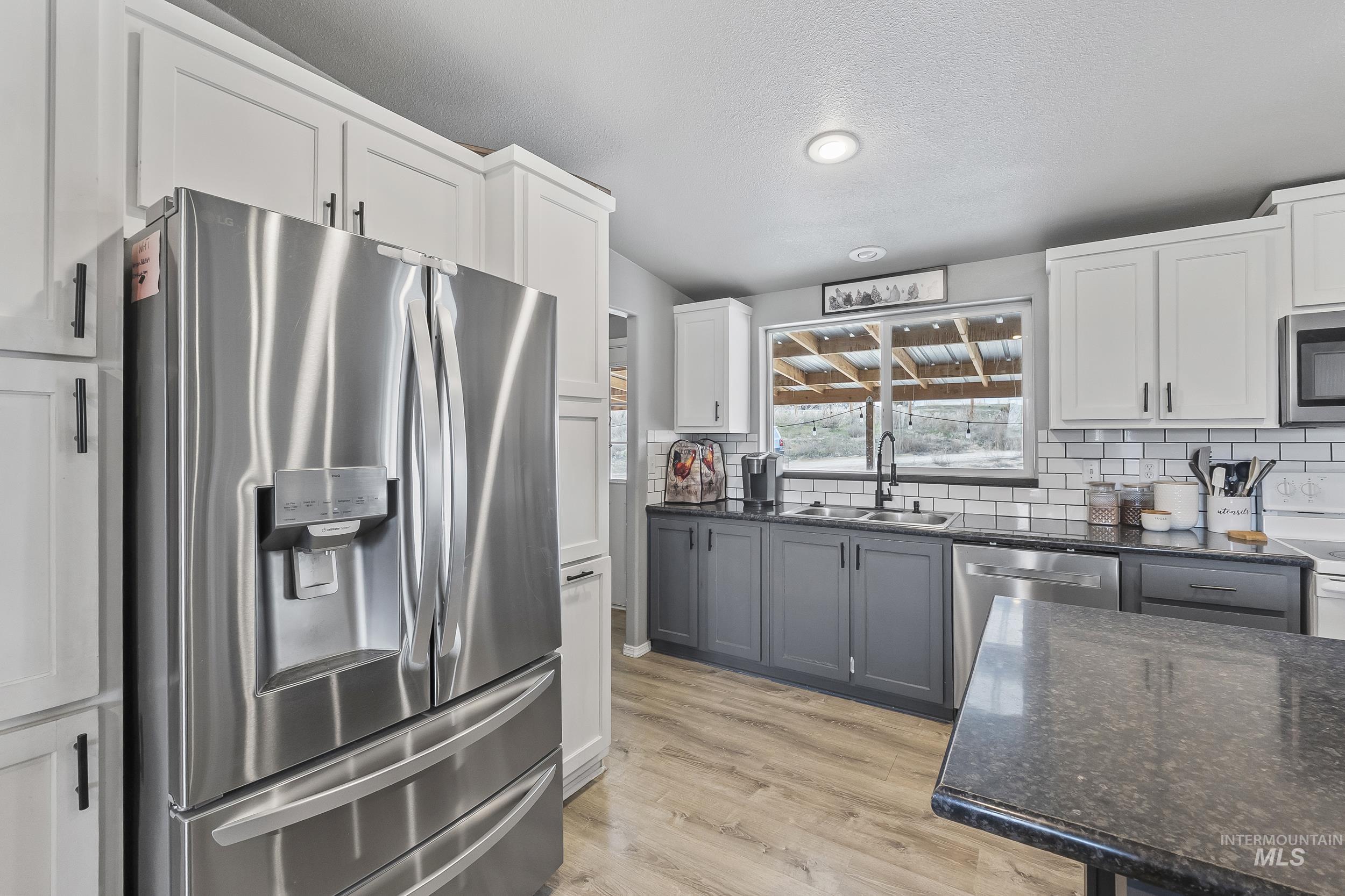 12944 Goodson Road Caldwell, ID 83607 - Photo 11 of 47 Kitchen featuring appliances with stainless steel finishes, gray cabinets, and white cabinets