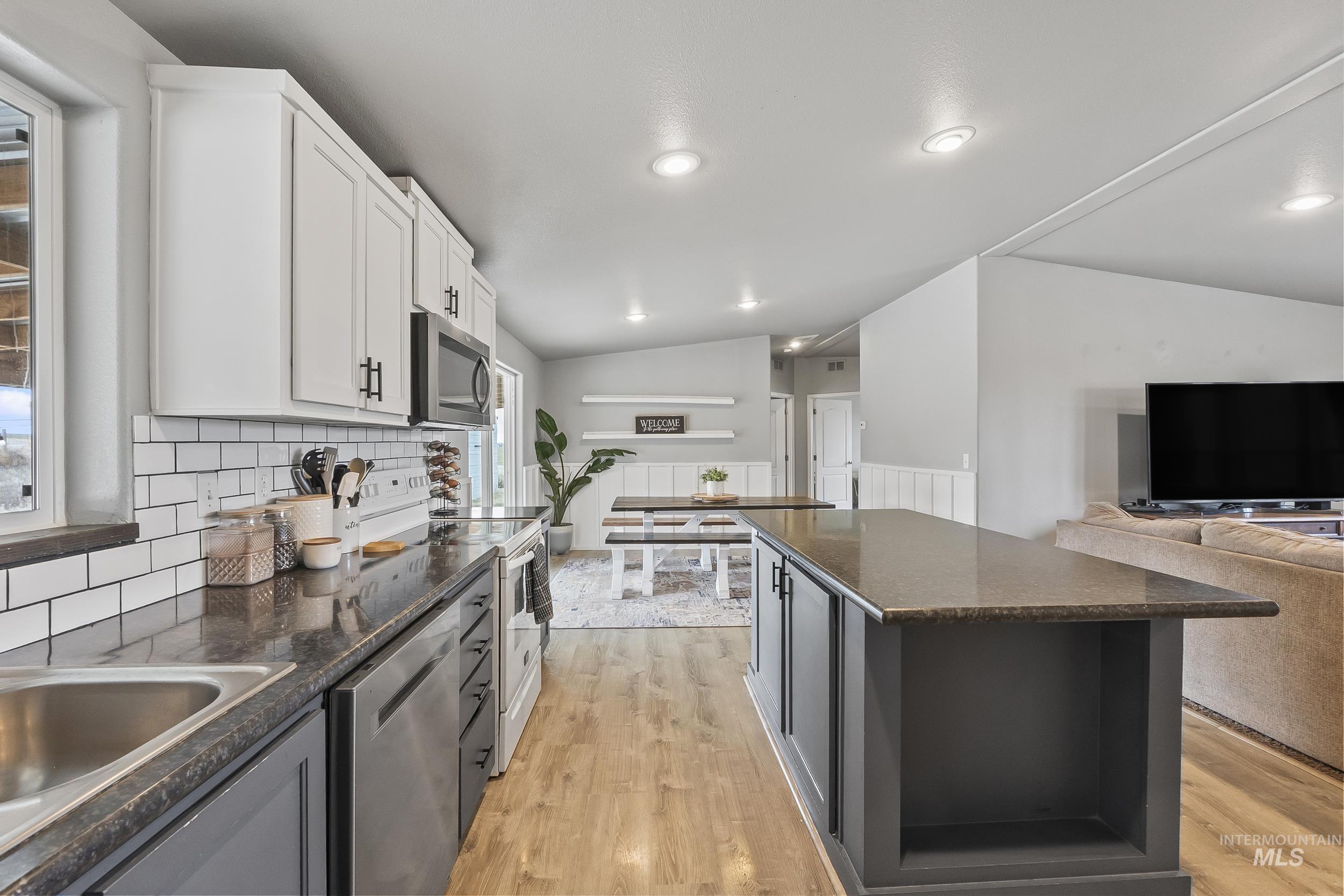 12944 Goodson Road Caldwell, ID 83607 - Photo 47 of 47 Kitchen with open floor plan, stainless steel appliances, a center island, light wood finished floors, and vaulted ceiling
