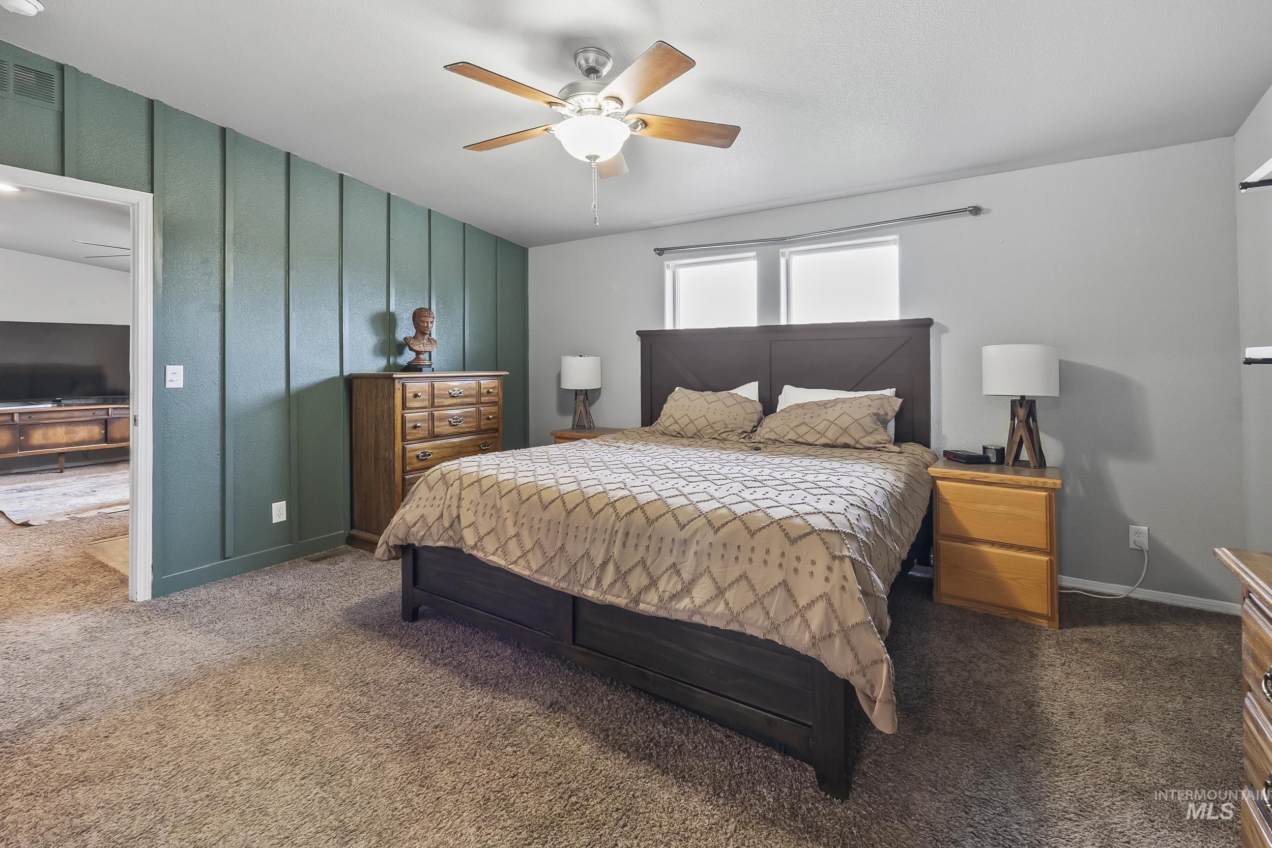 12944 Goodson Road Caldwell, ID 83607 - Photo 18 of 47 Bedroom featuring a decorative wall, a ceiling fan, and carpet
