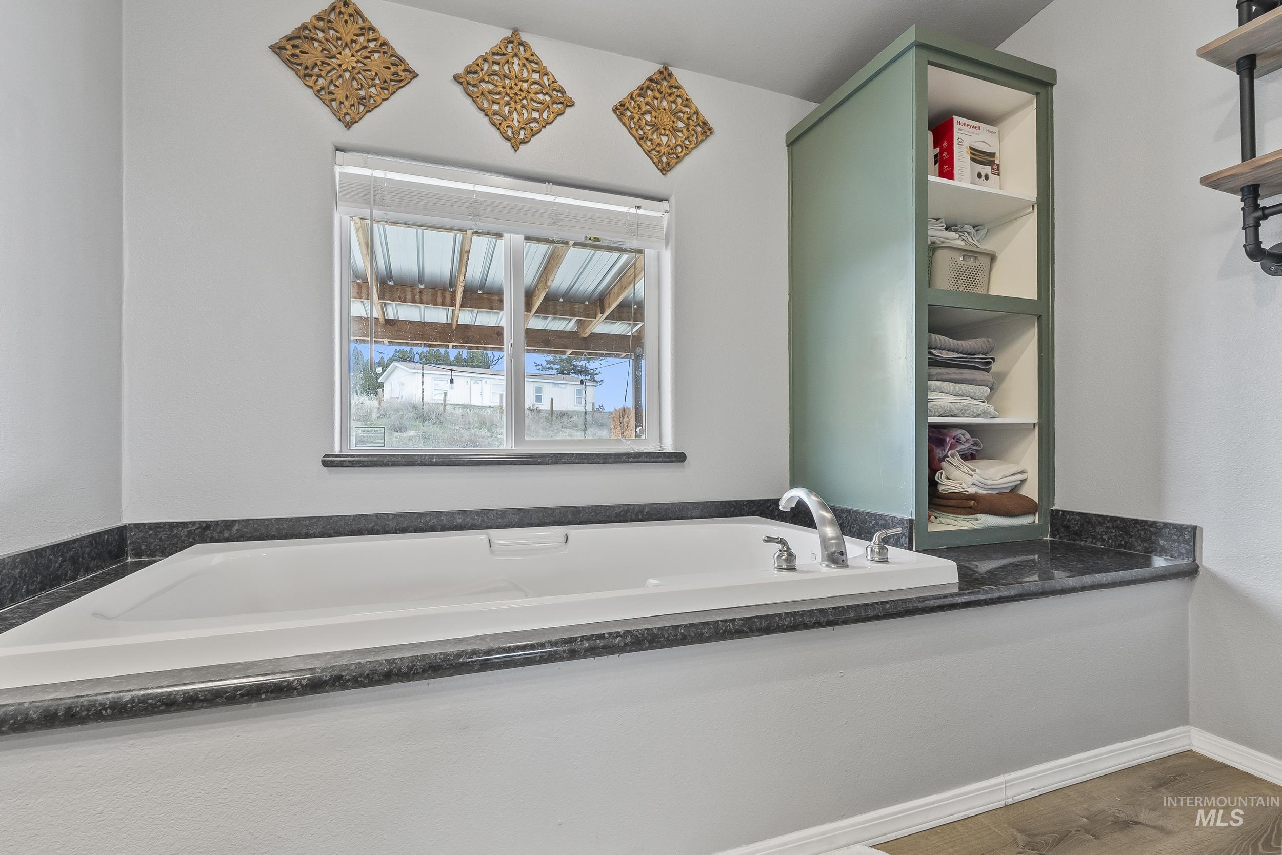 12944 Goodson Road Caldwell, ID 83607 - Photo 20 of 47 Bathroom with a bath and wood finished floors