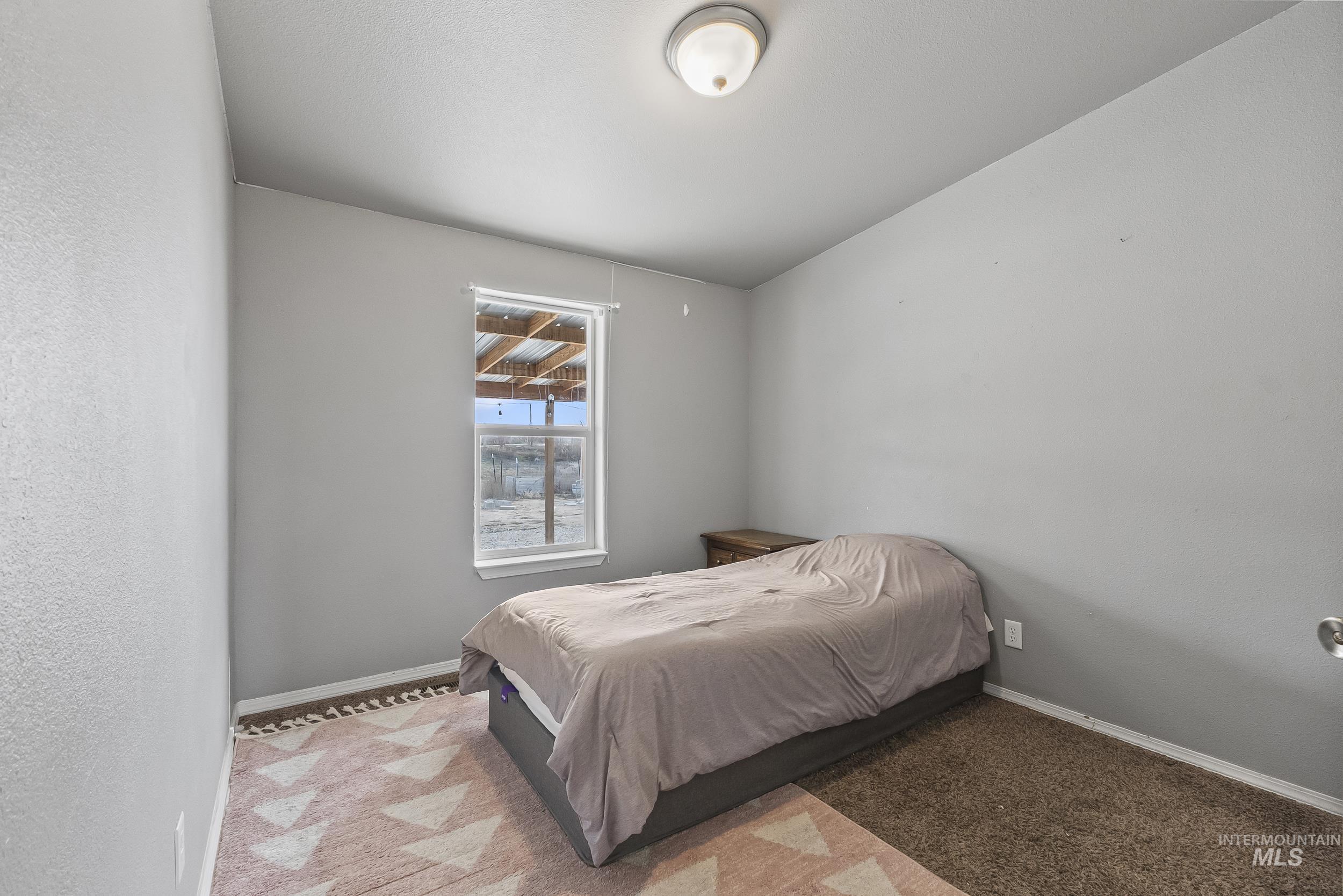 12944 Goodson Road Caldwell, ID 83607 - Photo 22 of 47 Carpeted bedroom with baseboards and a textured wall