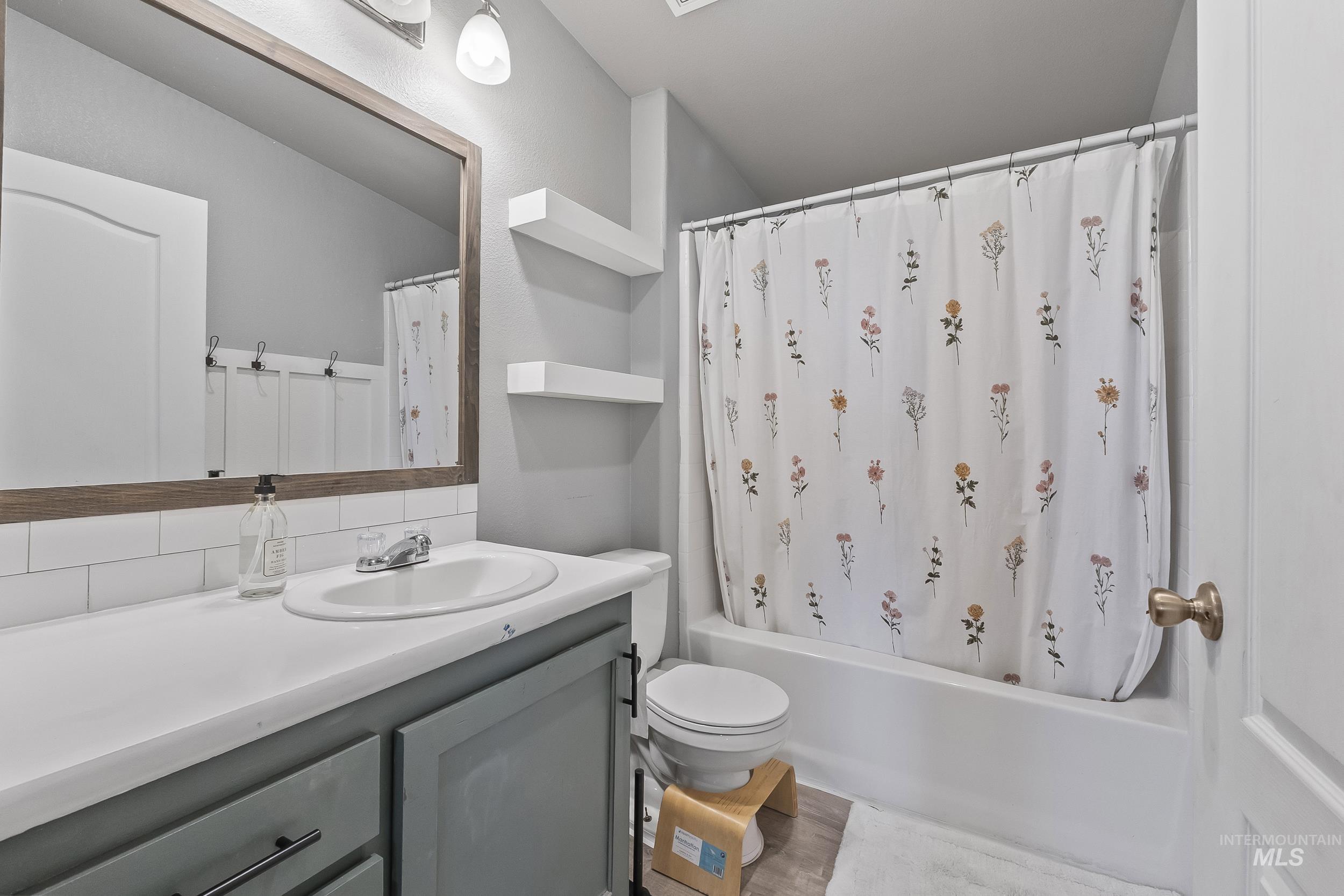12944 Goodson Road Caldwell, ID 83607 - Photo 24 of 47 Bathroom featuring vanity, shower / bath combination with curtain, and decorative backsplash