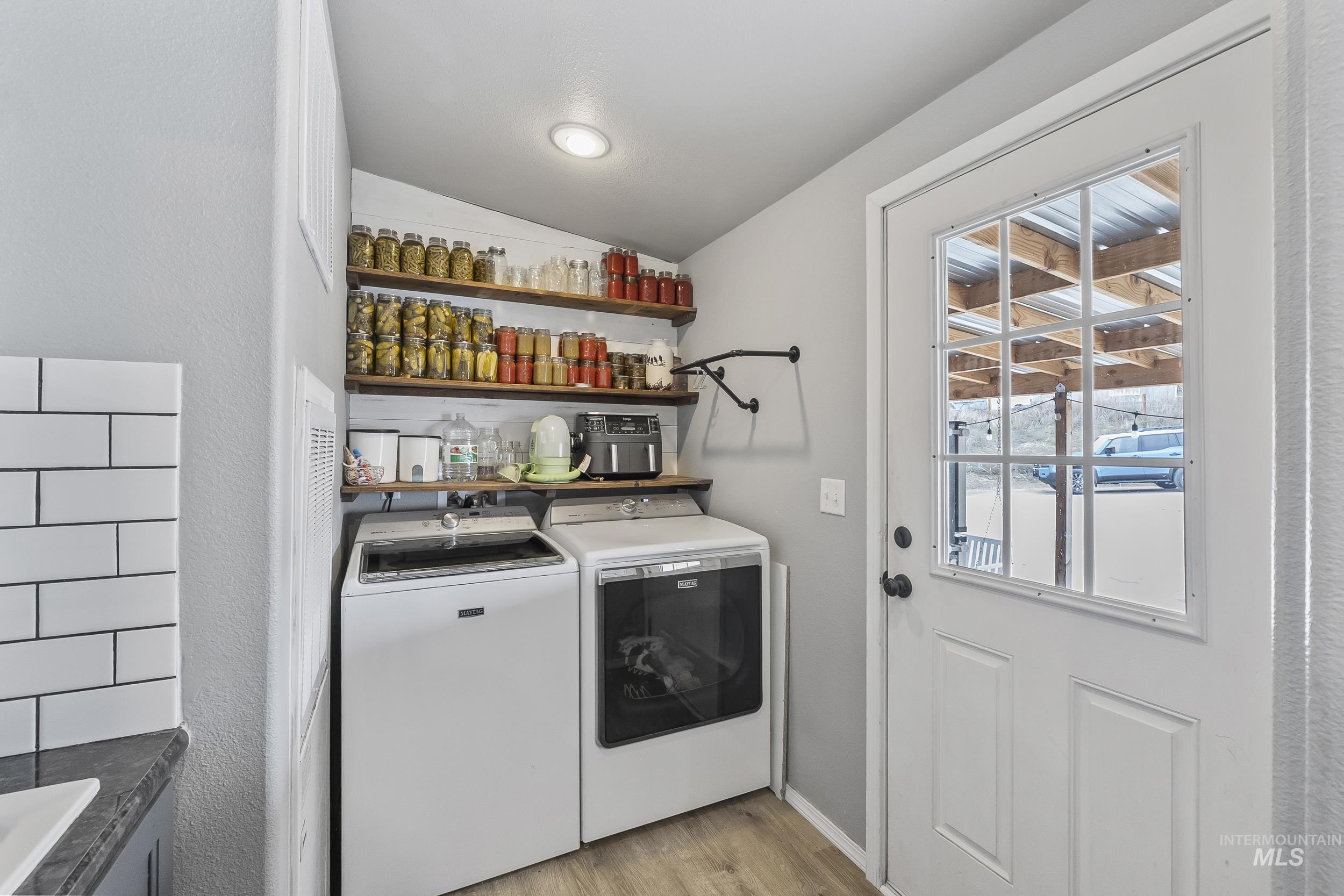 12944 Goodson Road Caldwell, ID 83607 - Photo 30 of 47 Washroom featuring vaulted ceiling, washer and dryer, and light wood-style flooring