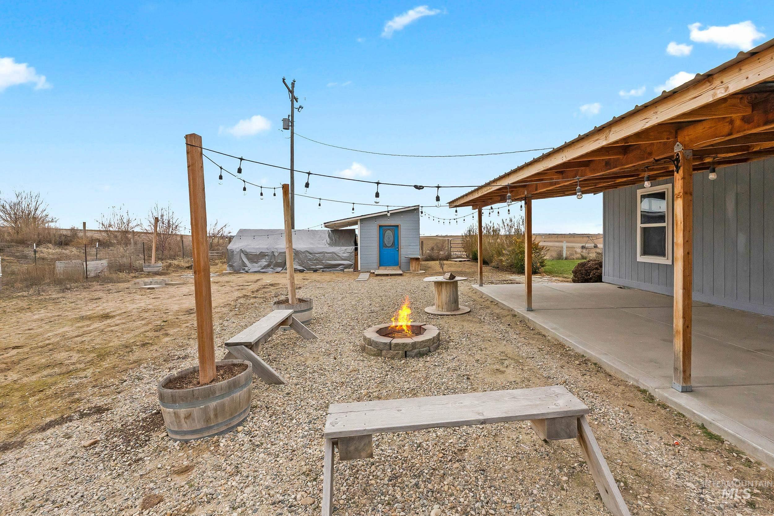 12944 Goodson Road Caldwell, ID 83607 - Photo 37 of 47 Fenced yard featuring an outdoor fire pit, a patio area, and a shed