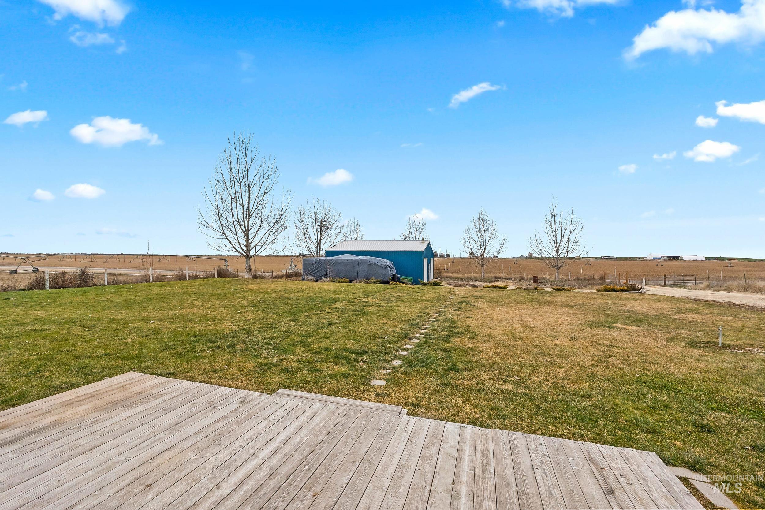12944 Goodson Road Caldwell, ID 83607 - Photo 41 of 47 Wooden terrace with a view of rural / pastoral area, a fenced backyard, and an outdoor structure