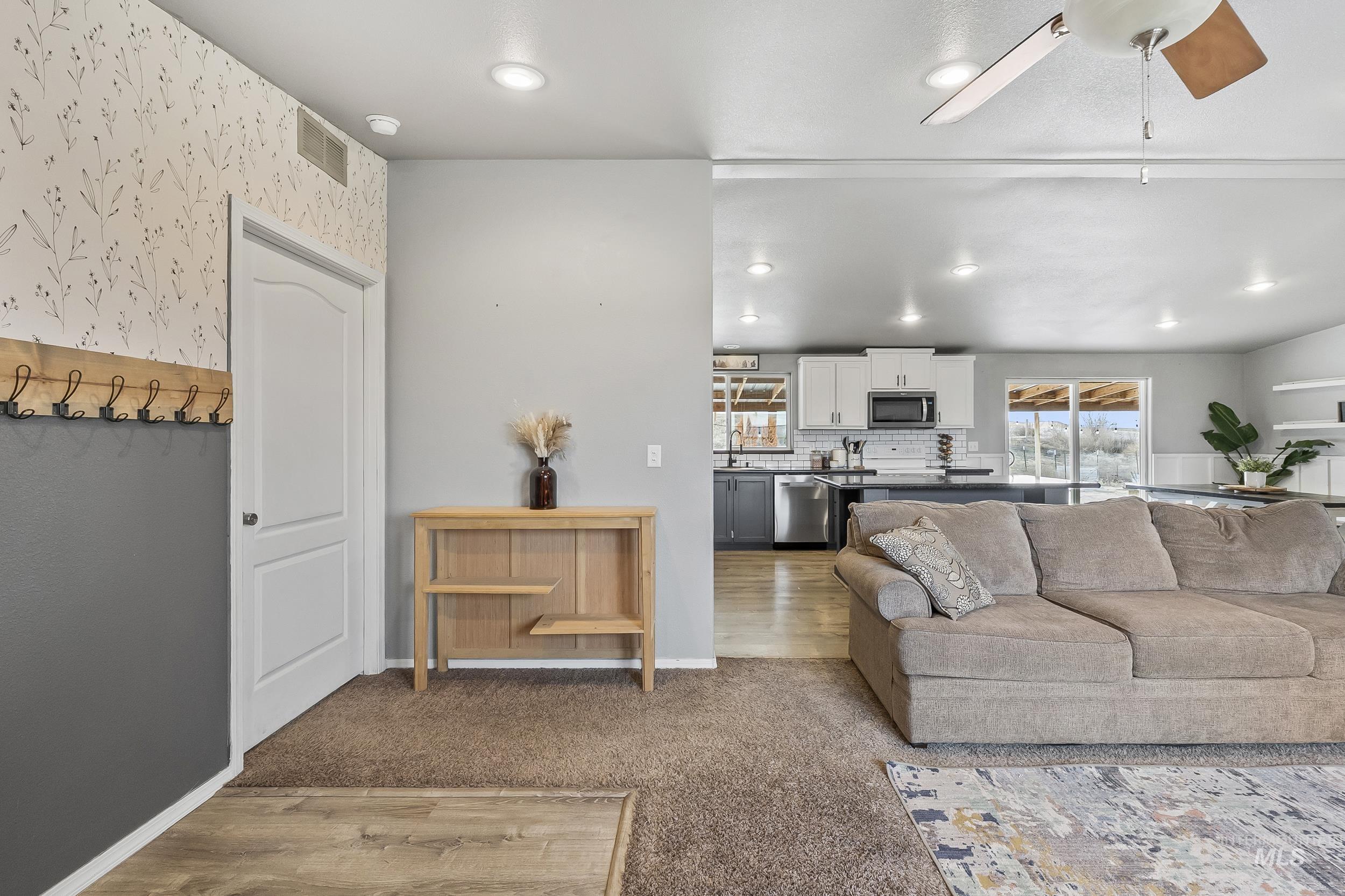 12944 Goodson Road Caldwell, ID 83607 - Photo 6 of 47 Living room featuring ceiling fan, recessed lighting, wallpapered walls, and light colored carpet