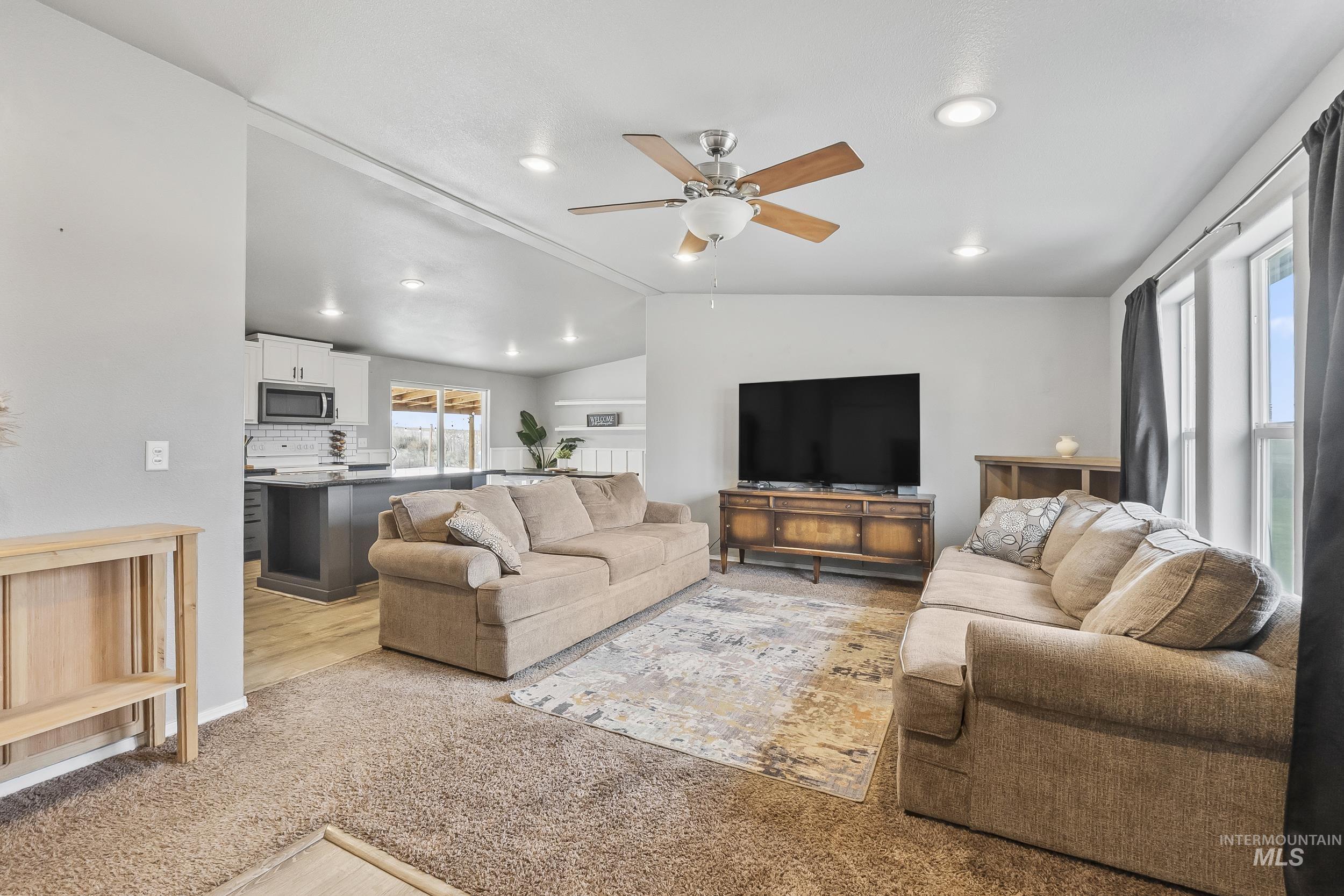 12944 Goodson Road Caldwell, ID 83607 - Photo 7 of 47 Living area with vaulted ceiling, light colored carpet, a ceiling fan, and recessed lighting