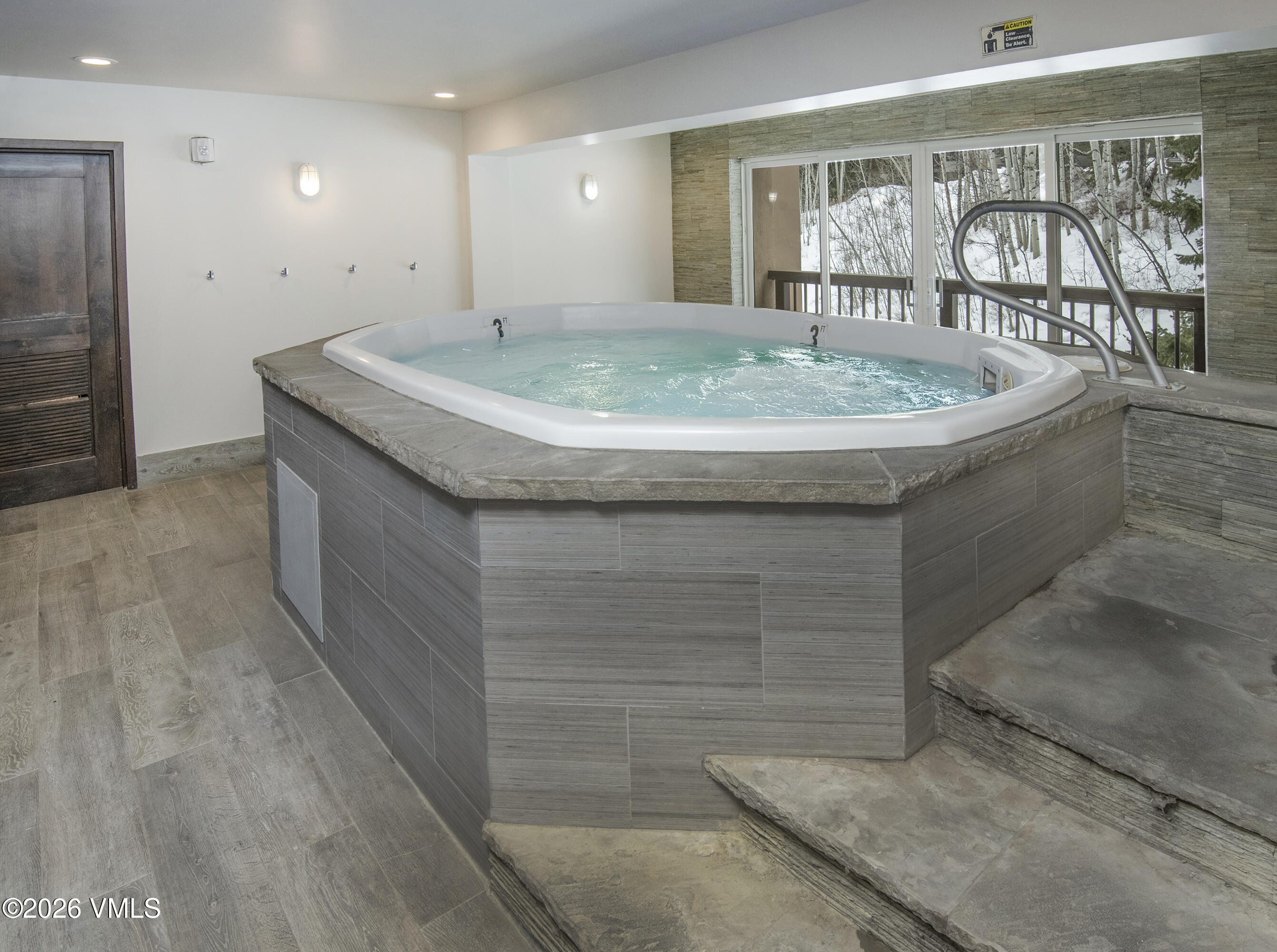 1650 Fall Ridge Road, Unit 202 Vail, CO 81657 - Photo 20 of 32 a room with a wooden floor and chandelier