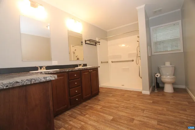 a bathroom with a granite countertop sink toilet and shower