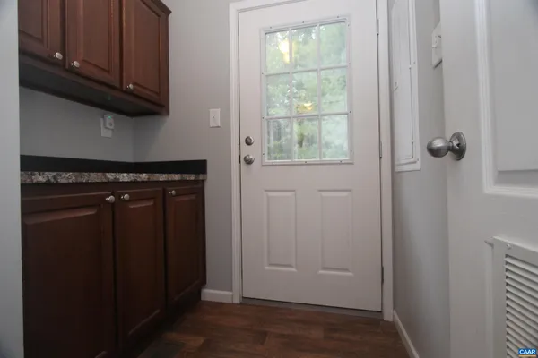 a view of a kitchen with wooden floor and cabinets
