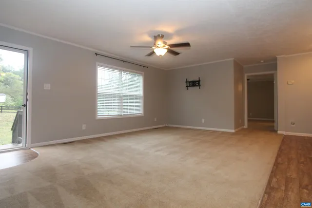 a view of a livingroom with a ceiling fan and window