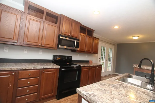 a kitchen with stainless steel appliances granite countertop a sink stove and microwave