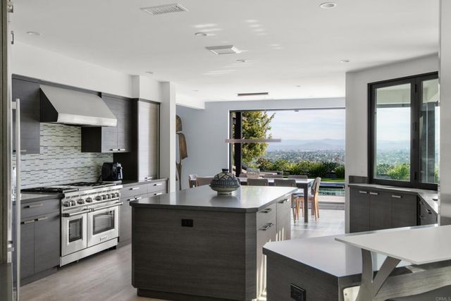 a dining hall with stainless steel appliances granite countertop a sink a stove and refrigerator