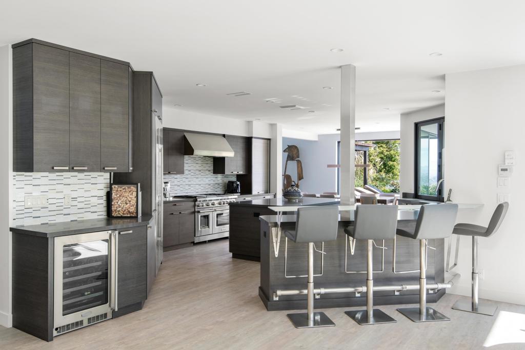 2807 Caminito Turnberry La Jolla, CA 92037 - Photo 14 of 50 a kitchen with stainless steel appliances kitchen island granite countertop a table and chairs in it