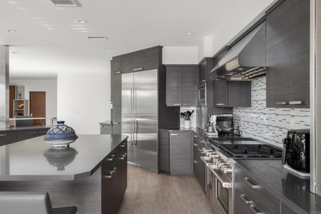 2807 Caminito Turnberry La Jolla, CA 92037 - Photo 15 of 50 a kitchen with stainless steel appliances kitchen island a sink stove and refrigerator