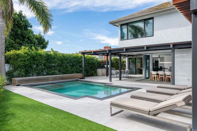 a view of a patio with table and chairs potted plants with floor to ceiling window