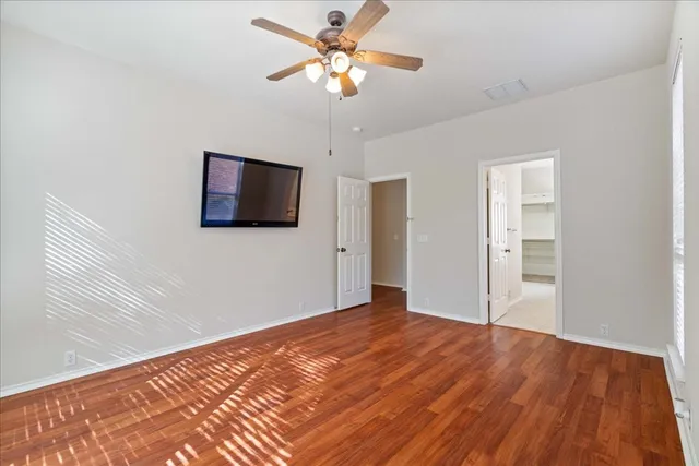 a bedroom with a large bed and a potted plant