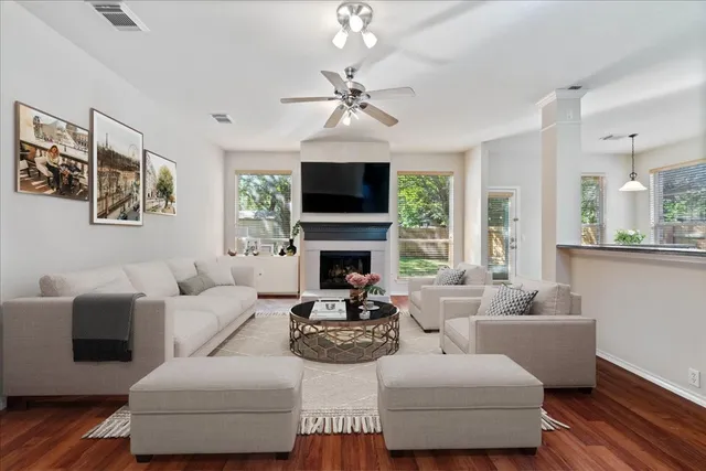 a living room with wooden floor and a fireplace