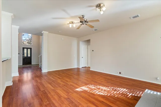 a view of a big room with wooden floor and a kitchen