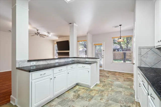 a kitchen with granite countertop a refrigerator sink and cabinets