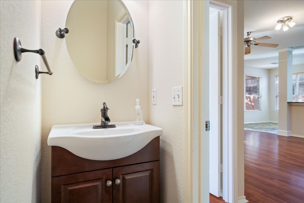 10937 Colonel Winn Loop Austin, TX 78748 - Photo 23 of 36 a bathroom with a sink a mirror and wooden floor