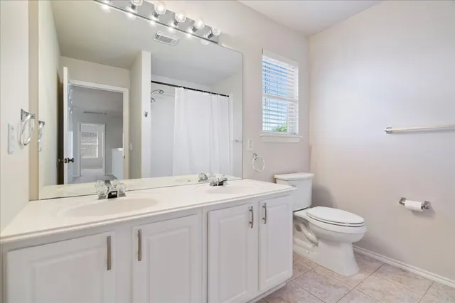 an empty room with windows and chandelier fan