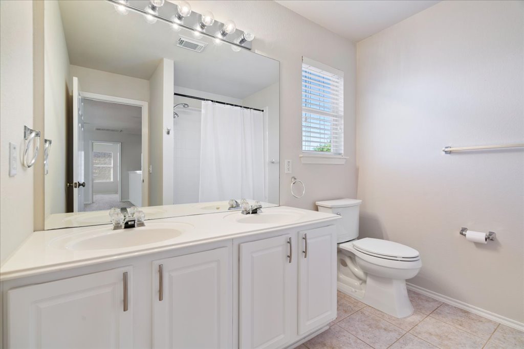 10937 Colonel Winn Loop Austin, TX 78748 - Photo 30 of 36 a bathroom with a sink toilet and mirror