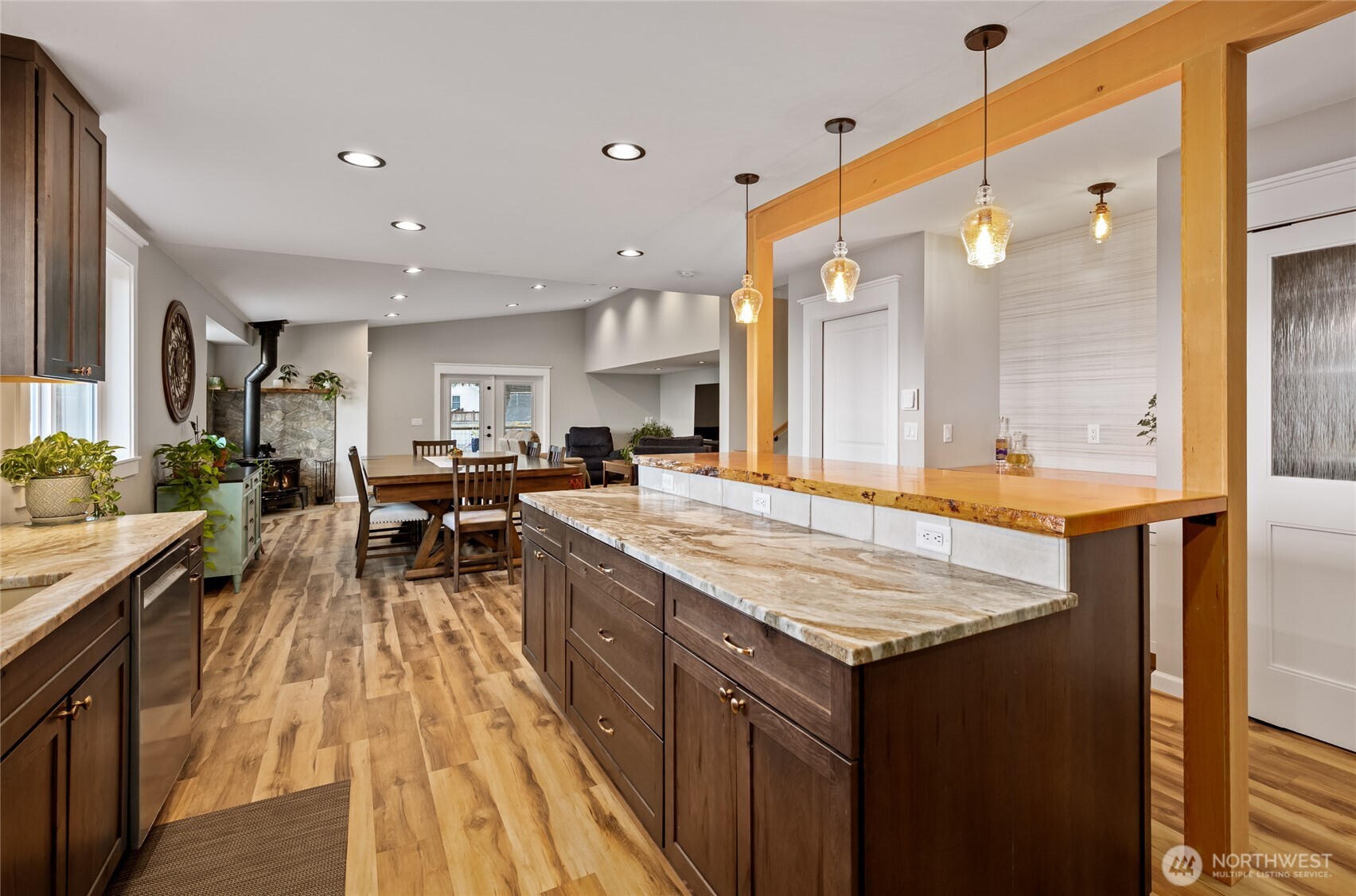 1726 63rd Street Southeast Everett, WA 98203 - Photo 10 of 37 a large kitchen with kitchen island a sink dishwasher a stove a dining table and chairs with wooden floor