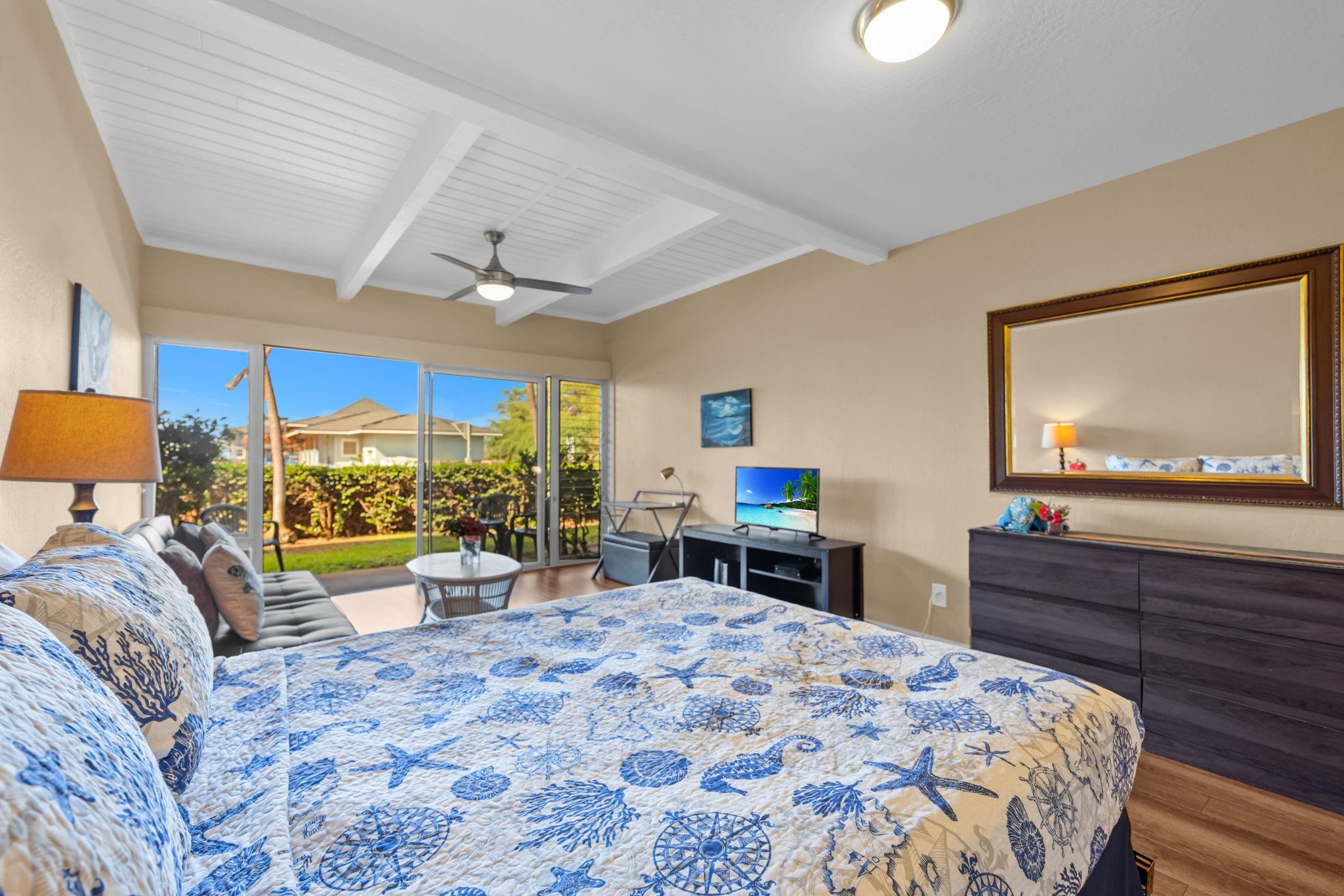 715 South Kihei Road, Unit 106 Kihei, HI 96753 - Photo 6 of 28 a bedroom with a bed a large window with table and chairs