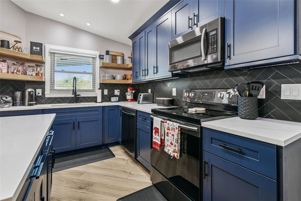 1729 Lakecrest Avenue Brandon, FL 33510 - Photo 18 of 51 a kitchen with stainless steel appliances granite countertop a stove a sink dishwasher and cabinets with wooden floor