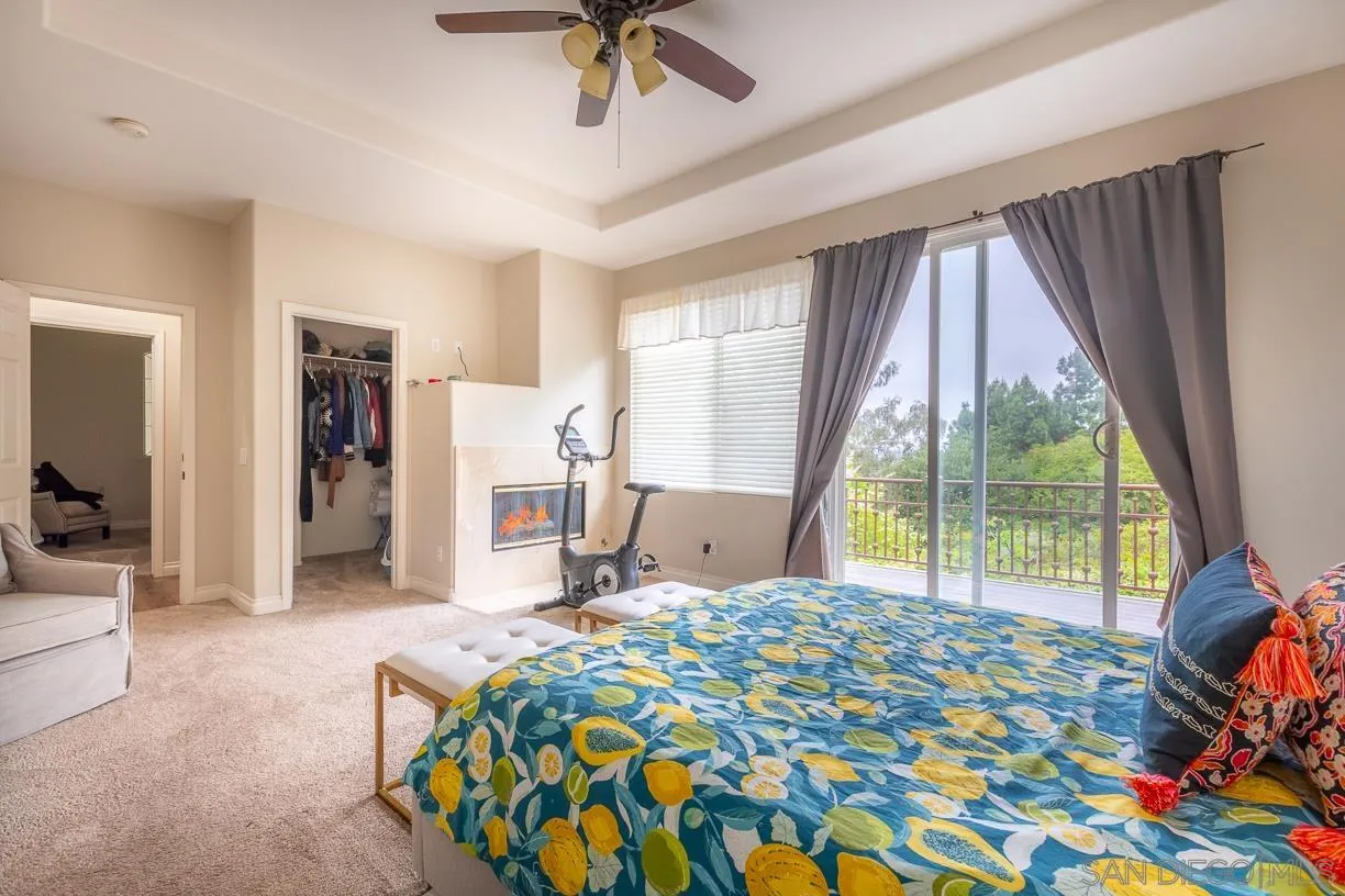 2435 Ridgegate Row La Jolla, CA 92037 - Photo 14 of 30 a bedroom with a bed a table and flat screen tv